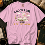 A Book A Day Keeps Reality Away T-Shirt: Whimsical Open Book in Blossom - Comfort Colors® T-Shirt