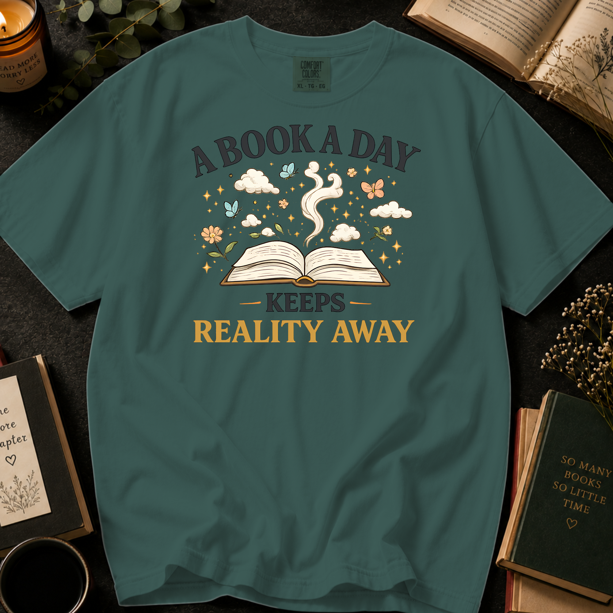 A Book A Day Keeps Reality Away T-Shirt: Whimsical Open Book in Blue Spruce - Comfort Colors® T-Shirt