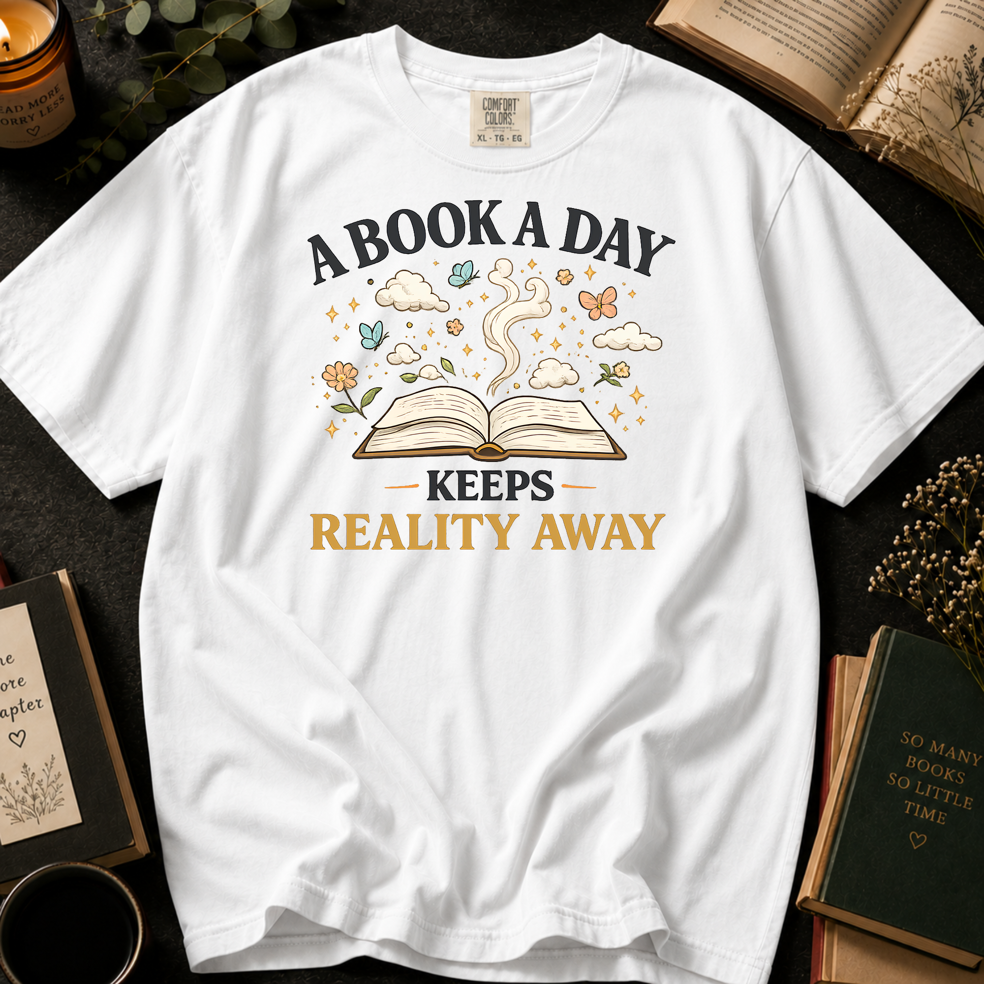 A Book A Day Keeps Reality Away T-Shirt: Whimsical Open Book in White - Comfort Colors® T-Shirt